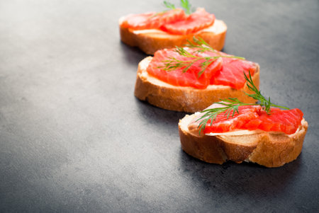 Sandwich with wheat bread with butter, salmon and herbs.の写真素材
