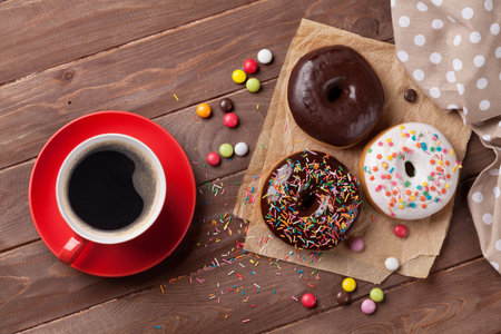 Donuts and coffee on wooden table. Top viewの写真素材