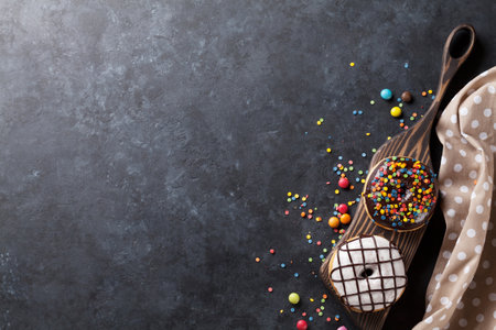 Colorful donuts and candies on stone table. Top view with copy spaceの写真素材