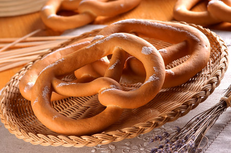 Bavarian pretzels in a wicker basket on a wooden tableの写真素材