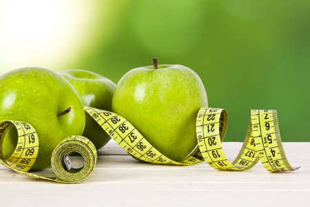 green apples with tape measure, concept of healthy dietの写真素材