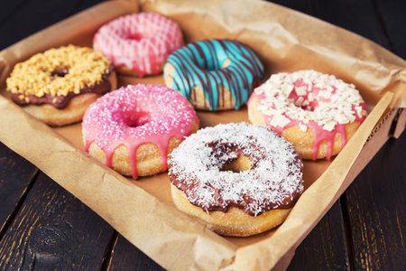A box with fresh homemade donuts with various toppings.の写真素材
