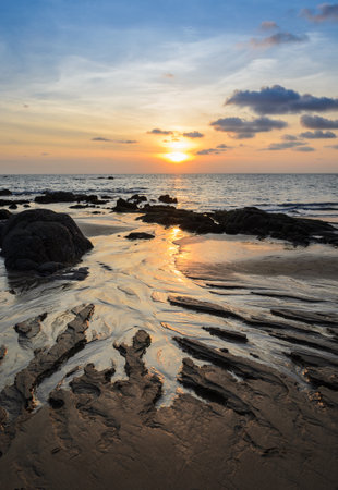 Tropical rock beach sunset with beautiful cloudscape skylineの写真素材