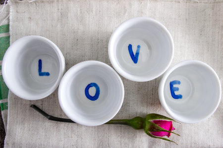 the word love and pink roses on the table, from aboveの写真素材
