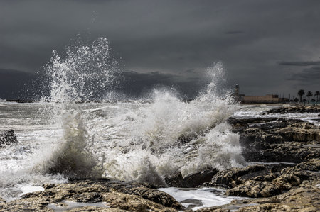 Stormy waves breaking on the rocks in the port of Essaouira, Moroccoの写真素材