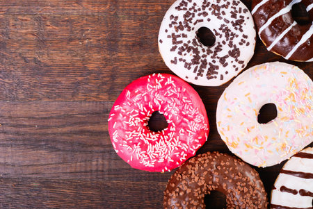 Background of colorful donats . On wooden boardの写真素材