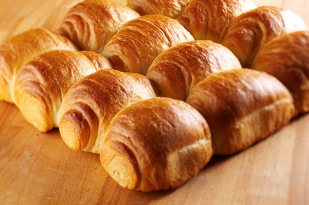 Freshly baked croissants on a wooden board, closeupの写真素材