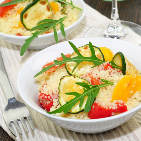 Couscous with vegetables and arugula on a wooden backgroundの写真素材