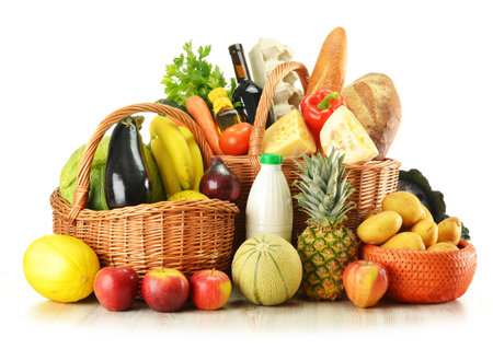 Composition with fruits and vegetables in wicker baskets isolated on whiteの写真素材