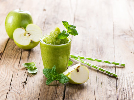 Smoothie made from apple and fresh fruit on a rustic wooden background with copy space.の写真素材