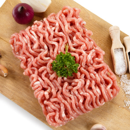 Minced meat on cutting board with garlic and parsley on white backgroundの写真素材
