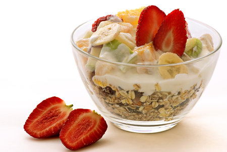 Healthy breakfast with muesli, yogurt and strawberries on white backgroundの写真素材