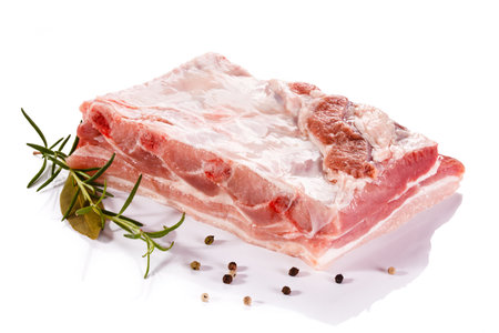 Raw pork ribs with rosemary and peppercorns on white backgroundの写真素材