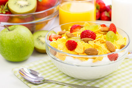 Healthy breakfast with cornflakes, milk and fruits on white backgroundの写真素材