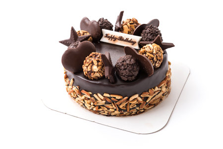 Chocolate cake on a white backgroundrated with chocolate and nutsの写真素材