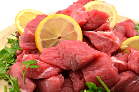 raw meat with lemon, parsley and parsley on a wooden boardの写真素材