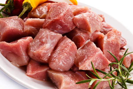 Raw pork meat with rosemary and pepper on a white background.の写真素材
