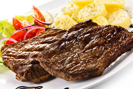 Grilled Beef Steak with Potatoes and Vegetables on White Backgroundの写真素材