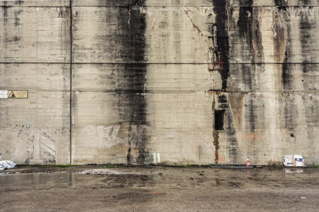 Old concrete wall of an industrial building with peeling paint. Abstract backgroundのeditorial素材