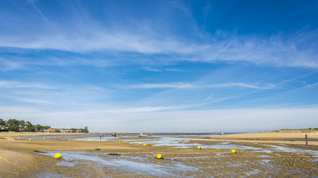 Beach at low tide on a sunny day with blue sky.のeditorial素材