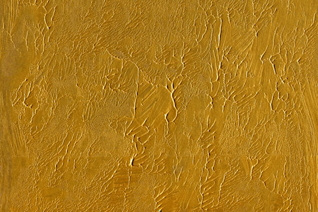 golden paint on a wall as a background, closeup of photoのeditorial素材