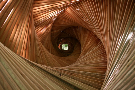 Wooden spiral staircase in the park. View from the inside.