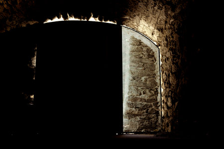 Light coming through the door of a medieval castle in the dark.のeditorial素材