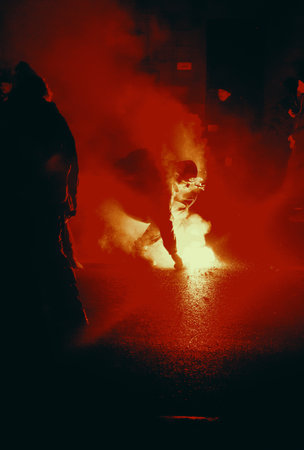 Halloween, horror and people concept. Silhouette of scary zombie woman and man with red smoke on...