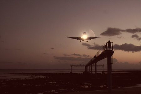 Airliner landing over the pier at sunset in San Diego, California.