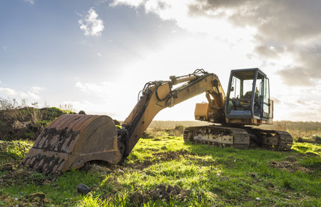 excavator at work on a construction site with a cloudy sky