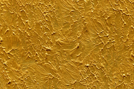 Yellow paint on the wall as a background. Texture of gold paintのeditorial素材