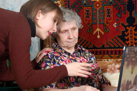 grandmother and granddaughter looking to the laptop