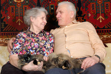 happy seventy year old couple with cat