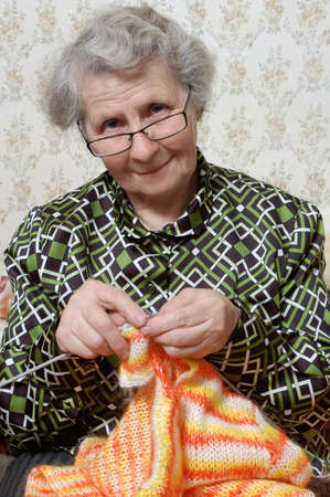 spectacled grandmother binds cardigan
