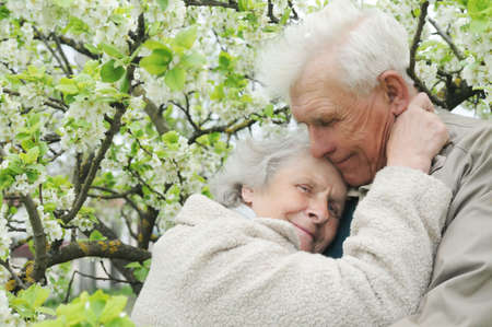 happy grandparents against a background of flowering gardenの写真素材