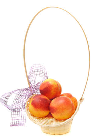 nectarines in basket with bow over whiteの写真素材
