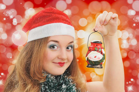 smiling girl in Santa hat with lantern in handの写真素材