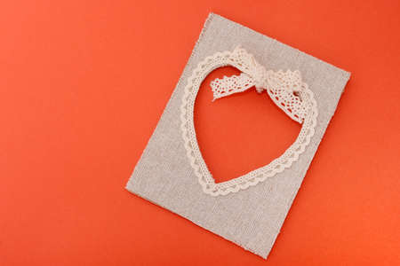 Heart-shaped canvas frame on orange paper. Top view. Valentine cardの写真素材
