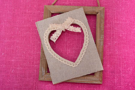 Disassembled frame with a heart lies on a pink canvasの写真素材