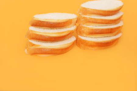 Photo of slices of white bread on ornage backgroundの写真素材