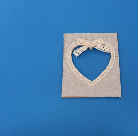 Heart shaped canvas frame on blue paperの写真素材