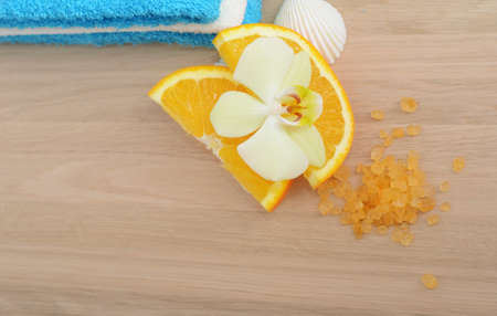 Flower of orchid on orange slices on wooden tableの写真素材