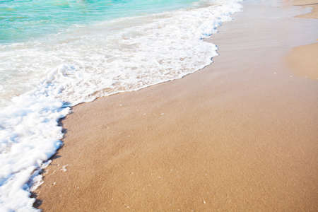 Waves wash over golden sand