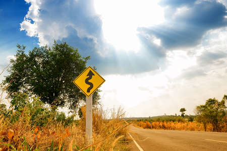 Winding road sign in the forest and mountain