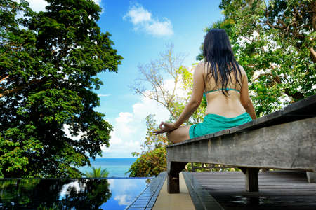 Woman training yoga and meditation at poolside ,concentrate on fingerの写真素材