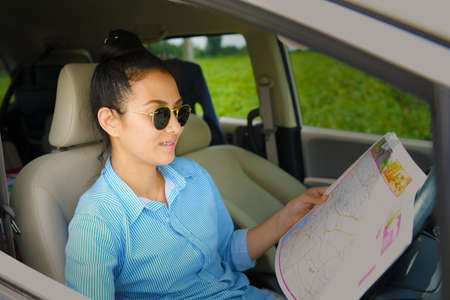 Business women looking for way in the car at countryside