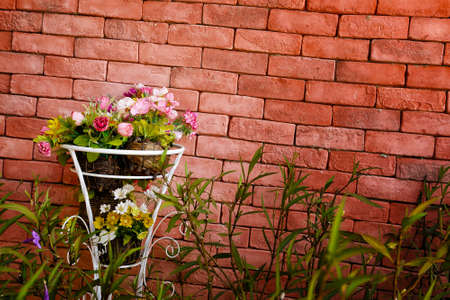 Decoration artificial flower in basket with red brick wallの写真素材