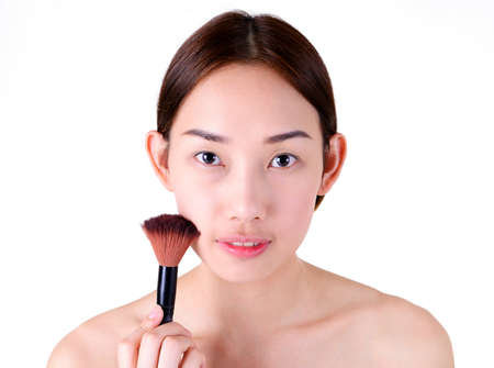 Beautiful asian woman with makeup brushes isolated on white backgroundの写真素材