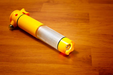 Yellow flashlight on wood boardの写真素材