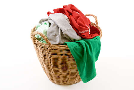 Clothes in a laundry wooden basket isolated on white backgroundの写真素材